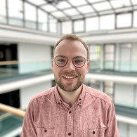 Mann lehnt sich an ein Geländer