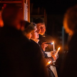 Menschen mit Kerzen in der Hand im Dunklen